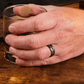 Man wearing a Black Zirconium (charcoal gray color) with Black Diamonds Wedding Ring while having a drink - Manly Bands