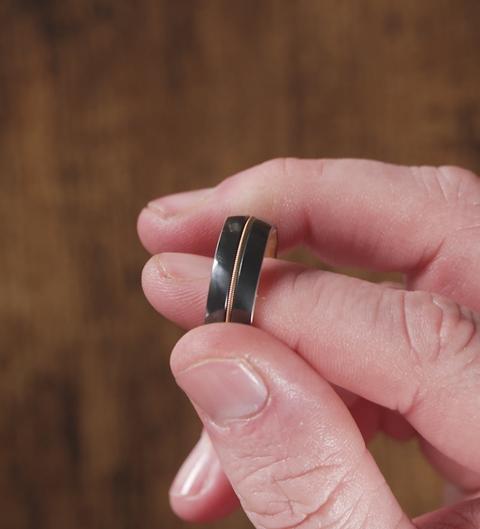 Trying on a men's wedding ring made of Black Zirconium, Guitar String, and Bird's Eye Maple-Fender- Manly Bands
